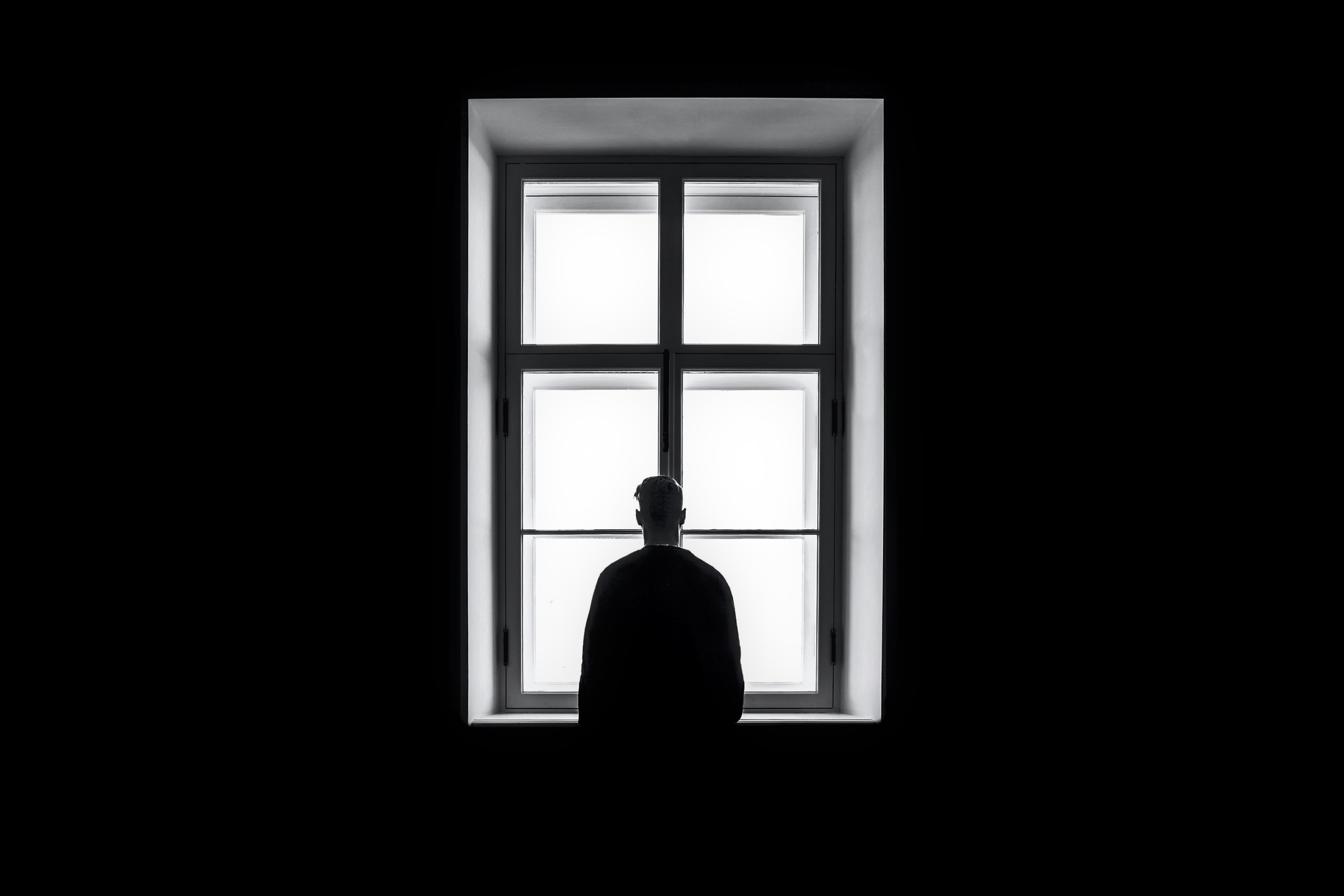young man looking out of a window